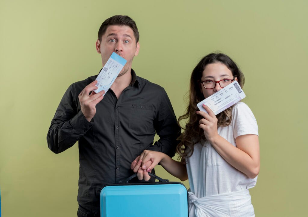 happy-young-couple-tourists-man-woman-holding-air-tickets-suitcase-light