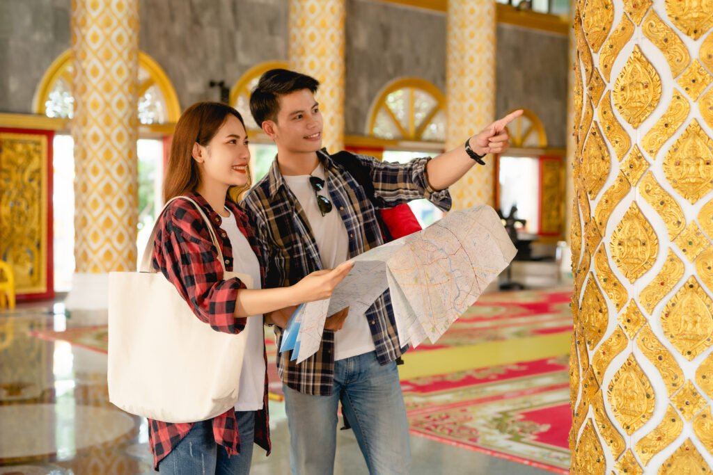 Asian couple backpackers checking map in Thai temple