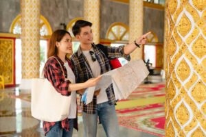 Asian couple backpackers checking map in Thai temple
